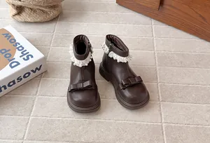 Détail de bottines marron pour fille avec dentelle de perles et nœud élégant