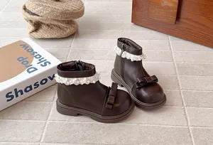 Détail de bottines marron pour filles avec dentelle, perles et nœud décoratif