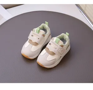 Close-up of toddler girls' cream sneakers with cute cartoon pig and velcro strap.