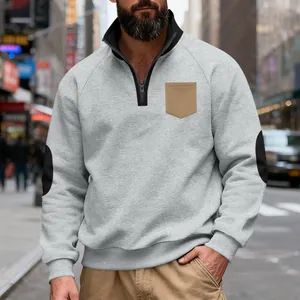 Men's grey fleece sweatshirt with half-zip, tan chest pocket and black elbow patches.