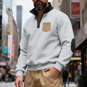 Detailed close-up of a men's grey heavy fleece quarter-zip sweatshirt with tan chest pocket
