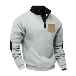 Detailed view of gray quarter-zip fleece sweatshirt with brown pocket and elbow patches