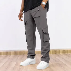 Detail view of men's dark grey cargo pants featuring multi-pocket design and ankle zippers.