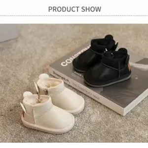 Detail showing black and cream toddler snow boots with warm plush lining on carpet.