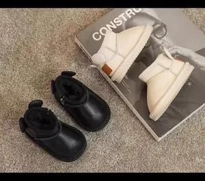 Two pairs of cozy children's winter snow boots with cute ear details on a soft carpet