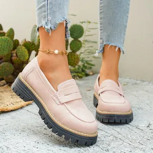 Detailweergave van roze matte loafers met dikke zwarte profielzolen in een buitenomgeving