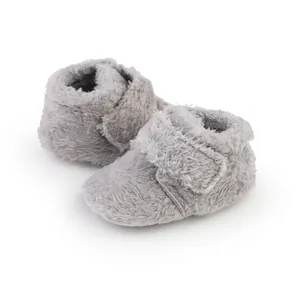 Macro view of grey fluffy baby walking shoes with soft soles for infants aged 0-1.