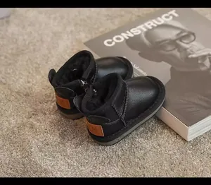 Macro view of black toddler winter boots featuring soft plush lining and side zipper