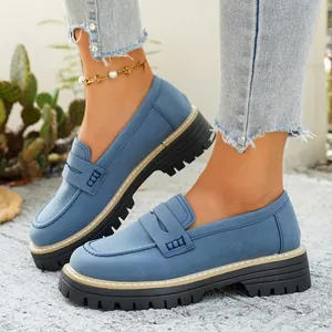Detail van blauwe matte loafers met dikke plateauzolen en retro Britse stijl design