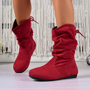 Detail view of stylish red suede mid-calf slouch boots with back bow ties for winter