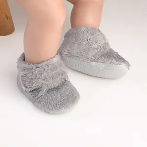 Detailed view of gray plush baby walking shoes with secure non-slip dotted soles