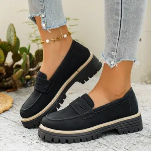 Gedetailleerd overzicht van zwarte suède platformloafers met dikke zool en retro