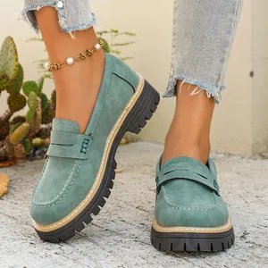 Detailweergave van saliegroene suède chunky loafers met dikke zool
