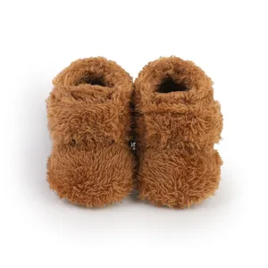 Close-up detail of soft brown fluffy faux fur baby booties for infants 0-1 year old