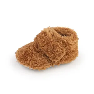 Close-up detail of fuzzy brown infant walking shoes with soft plush texture for babies.