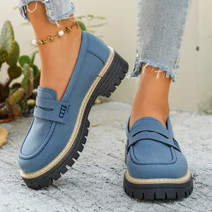 Detailopname van blauwe matte loafers met dikke profielzool op een model.