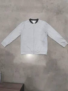 Detailed view of a grey minimalist casual zip-up bomber jacket with a black collar