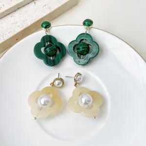 Boucles d'oreilles fleurs vintage avec perles et motif malachite sur une assiette blanche