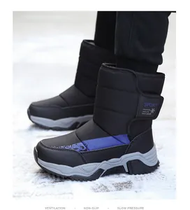 Detalle de botas de nieve impermeables para niños en color negro y azul en un entorno nevado