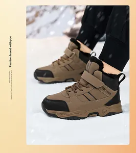 Detailed view of boys' insulated brown snow boots worn in a snowy outdoor setting.