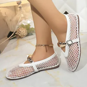 Gros plan détaillé des sandales plates en maille blanche avec une boucle coeur dorée chic