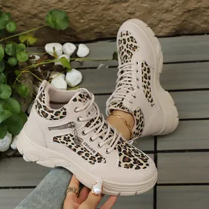 Vue détaillée de baskets beiges compensées avec empiècements léopard stylés et semelles épaisses.