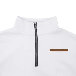 Vue détaillée d'un sweat-shirt blanc à demi-zip avec col montant et détails en cuir