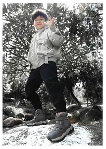 Outdoor detail of boy's grey fleece-lined snow boots with non-slip soles for winter