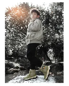 Detailed outdoor view of boy's green winter snow boots with thick non-slip soles in park