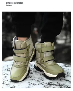 Warm green kids' snow boots with velcro straps for outdoor winter exploration in snow.