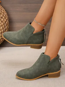 Detail shot of olive green pointed toe ankle boots with back zipper and chunky heels