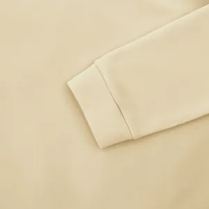 Gros plan du poignet côtelé d'un sweat-shirt en polaire de couleur crème.