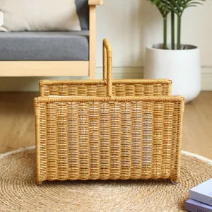 Woven faux rattan magazine basket with central handle on jute rug in cozy home interior.