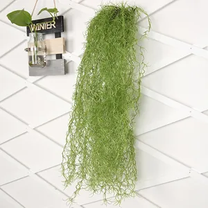 Detail of artificial Spanish moss hanging on a white trellis for wall decoration.