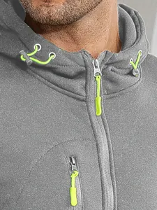 Detail view of a grey fleece hoodie showing neon green zipper pulls and fabric texture