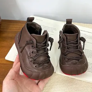 Detailansicht von braunen Leder-Kinderschuhen mit warmem Futter und auffälliger roter Sohle