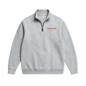 Vue de face d'un sweat-shirt gris pour homme avec demi-zip, col montant et écusson.