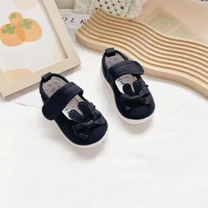 Detail of navy canvas toddler shoes with cute rabbit ears and bow decoration on top