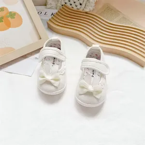Detail view of white toddler girl canvas shoes featuring cute bunny ears and a bow