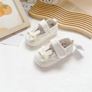 Detailed view of white baby girl canvas walking shoes with cute rabbit ears and bow