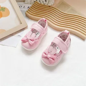 Close-up of pink baby girl walking shoes featuring cute bunny ears and bow detail