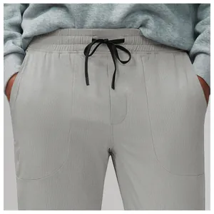 Detailed view of breathable mesh fabric and drawstring waistband on men's gray sports pants
