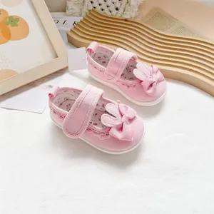 Detailed close-up of pink toddler shoes featuring cute bunny ears and a ribbon bow