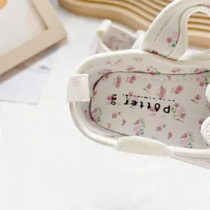 Close-up of baby girl's canvas shoe showing floral insole and soft padded interior
