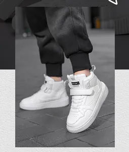Vista dettagliata di sneaker alte bianche con chiusura in velcro su pavé cittadino