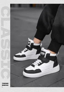 Vista laterale di sneakers alte bianche e nere alla moda indossate in un ambiente urbano