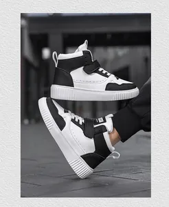 Dettaglio delle sneakers high-top bianco e nero con velcro e fori traspiranti.