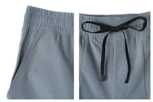 Close-up of quick-dry sports pants showing breathable mesh fabric and drawstring