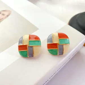 Vintage geometric enamel stud earrings with colorful grid pattern and shiny gold trim.