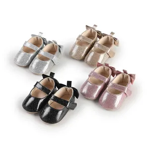 Collection of glittery baby girl shoes with bows in silver, gold, pink, and black.